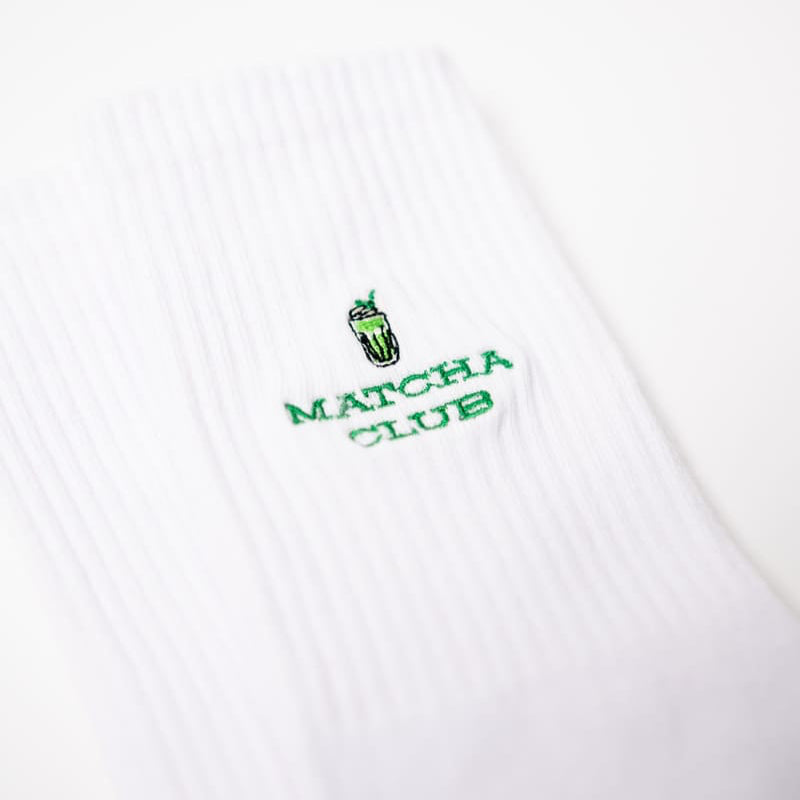 Nahaufnahme der weißen Matcha Club Socken von arrel mit grünem Design