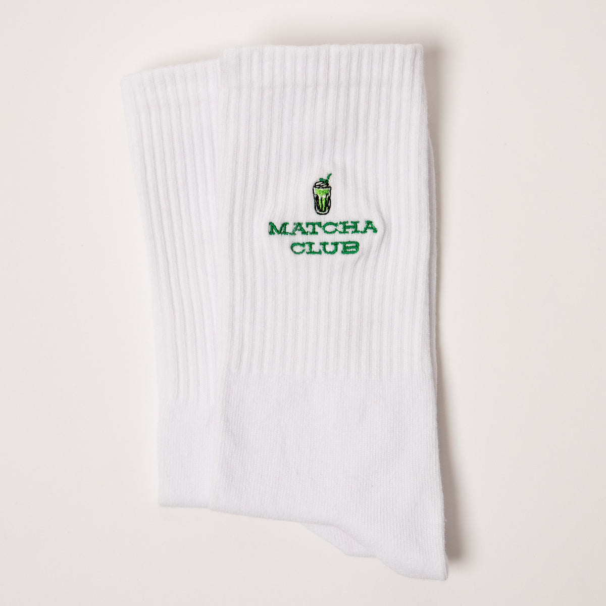 weiße Matcha Club Socken mit grünem Design von arrel