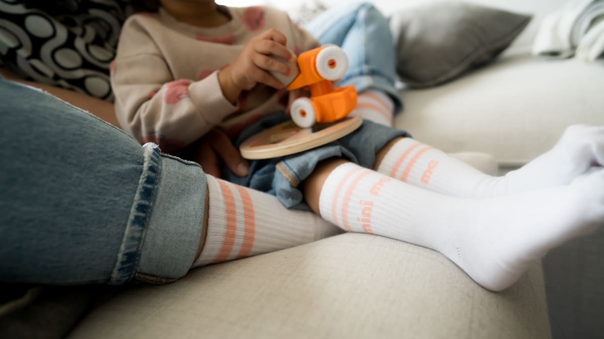 mini me Socken für Kinder. Kind auf dem Schoß eines Erwachsenen