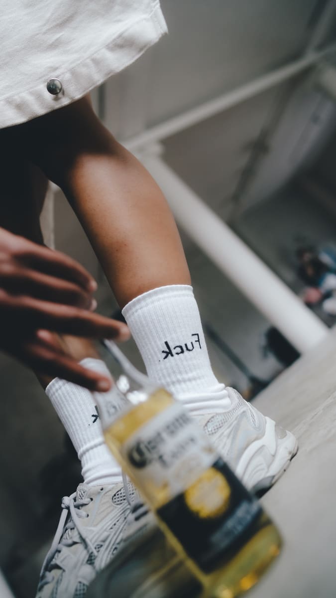 .kcuF Statementsocken von arrel mit Sneaker und Flasche