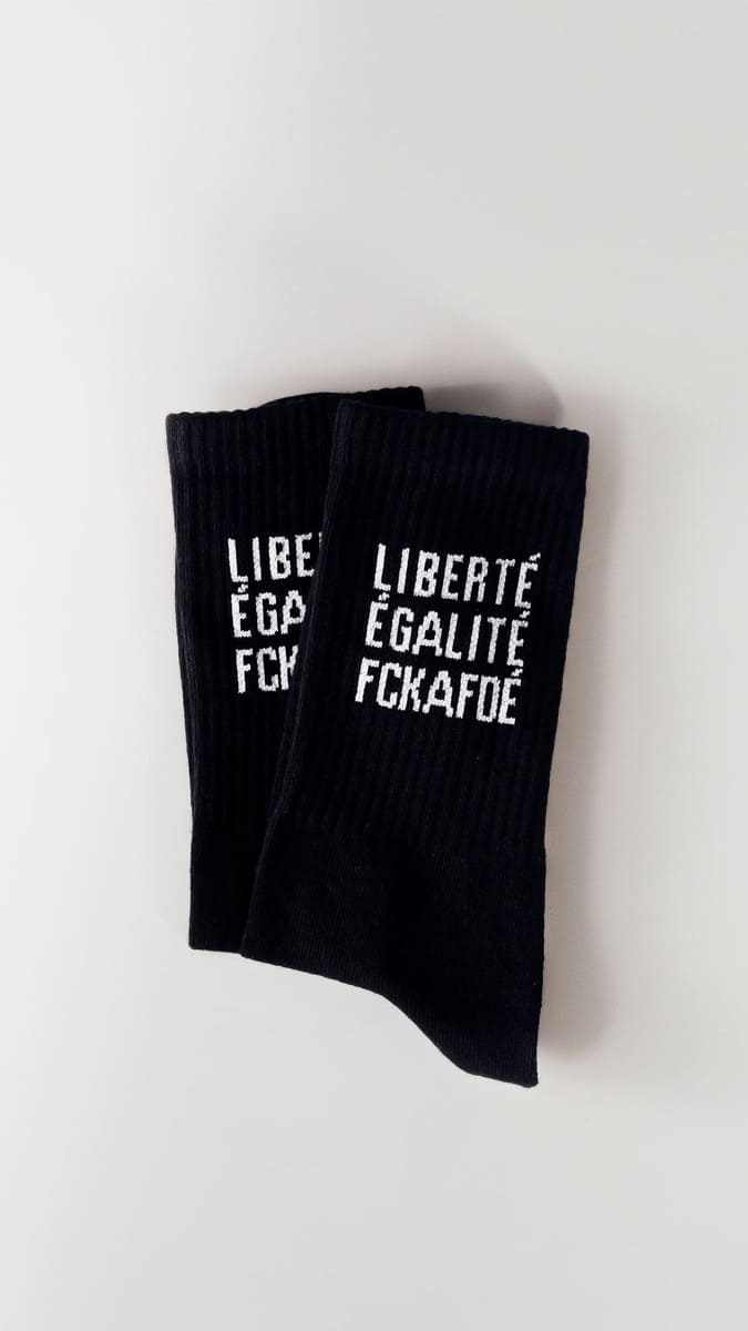 Liberté. Égalité. FCKAFDÉ Statement Socken in schwarz vor weißem Hintergrund