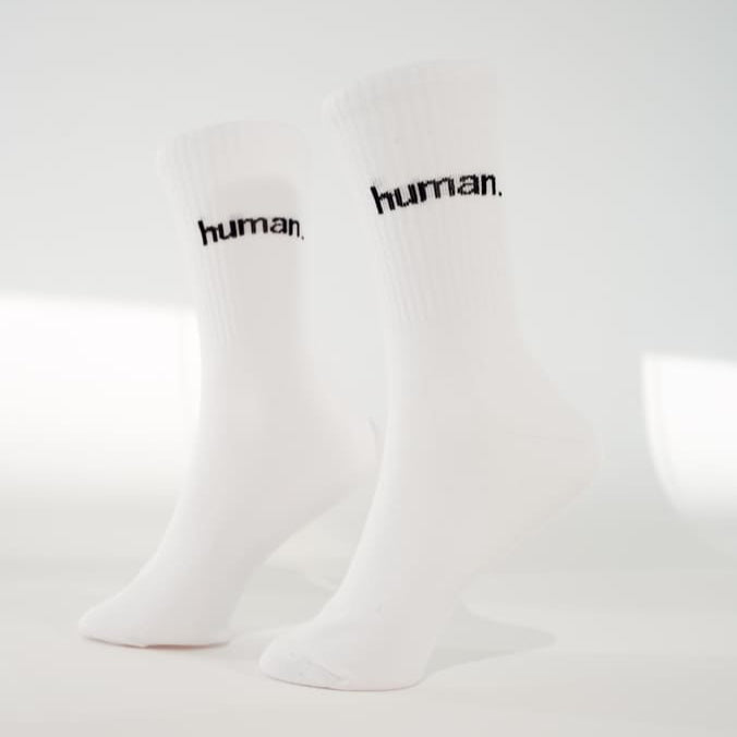 human. Statementsocken von arrel in weiß mit schwarzer Schrift am Modelfuß