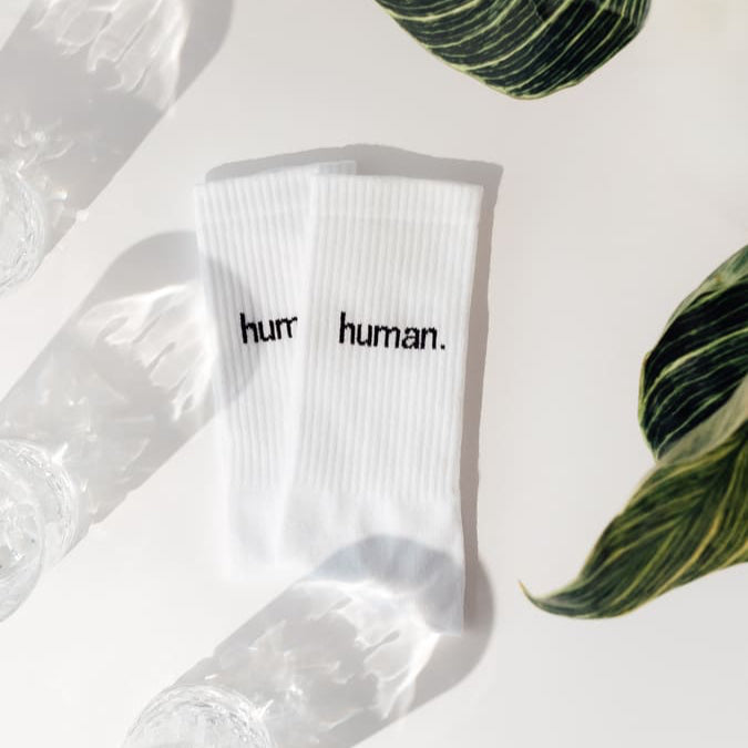 human. Statementsocken von arrel in weiß aus Bio-Baumwolle mit Glas und Pflanze