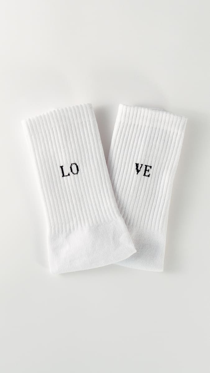 Love statementsocken von arrel in weiß mit schwarzer Schrift