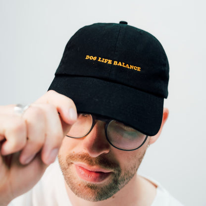 dog life balance unisex dad cap in schwarz mit orangener Schrift von arrel am männlichen Model