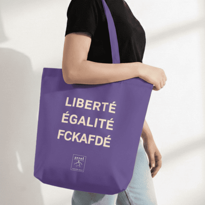 fckafd tote bag in Lila mit cremefarbener Schrift von einer Frau getragen
