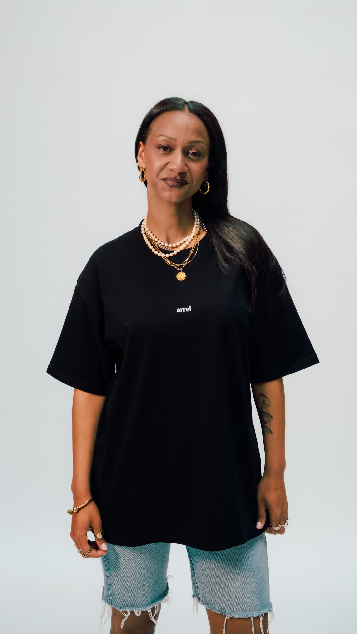 schwarzes arrel unisex oversized t-shirt am weiblichen Model und Ketten von vorne