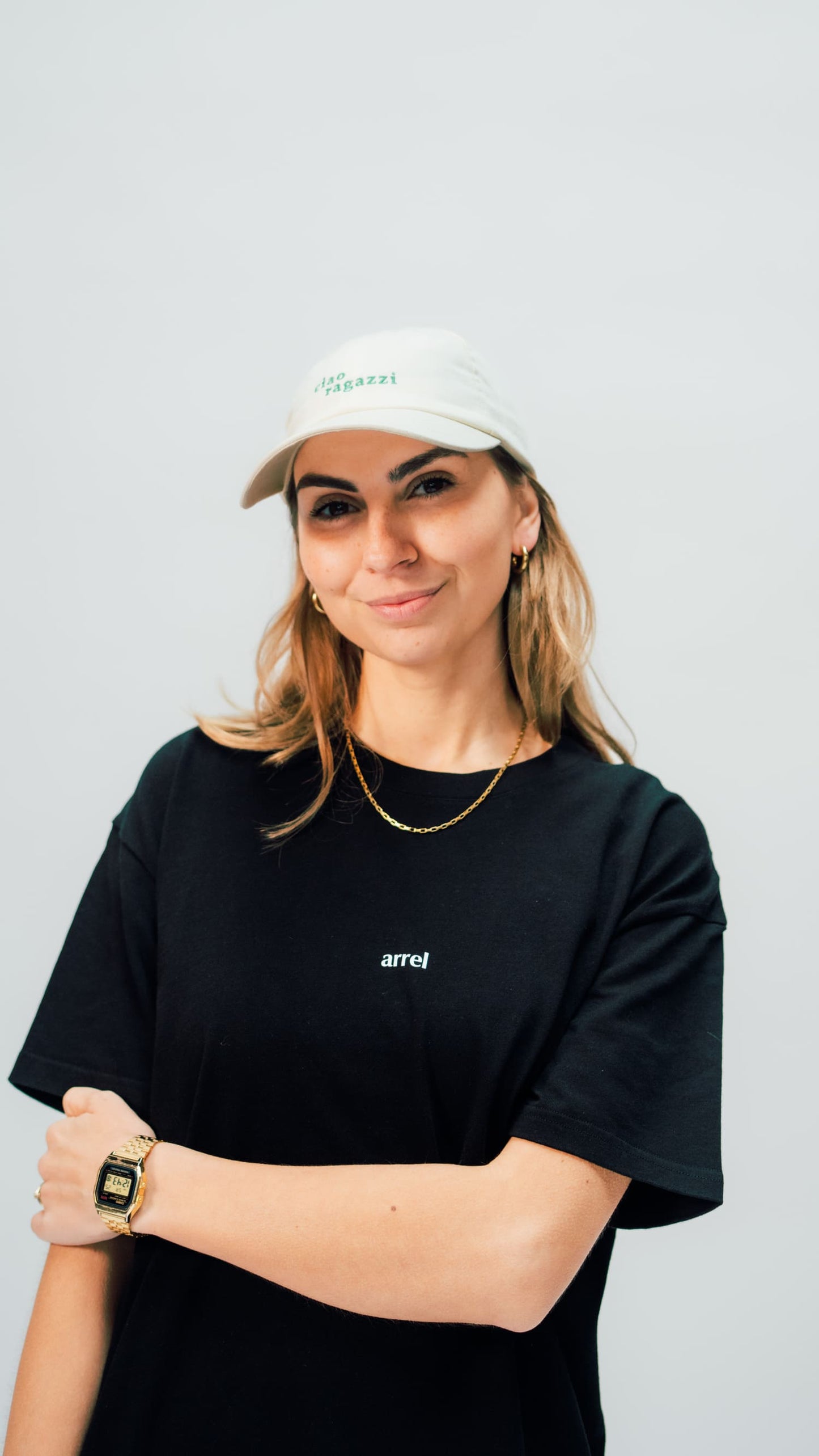 Nahaufnahme des schwarzes arrel unisex oversized t-shirt am weiblichen Model mit Cap von vorne