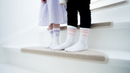 mini me und ramba zamba Socken für Kinder am Kinderfuß auf weißer Treppe