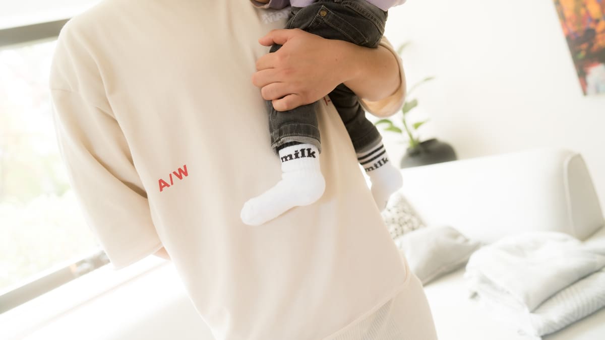 milk Socken von arrel mit Kind auf dem Arm