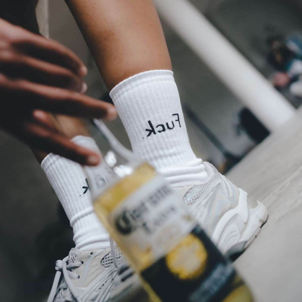 .kcuF Statementsocken von arrel mit Sneaker und Flasche