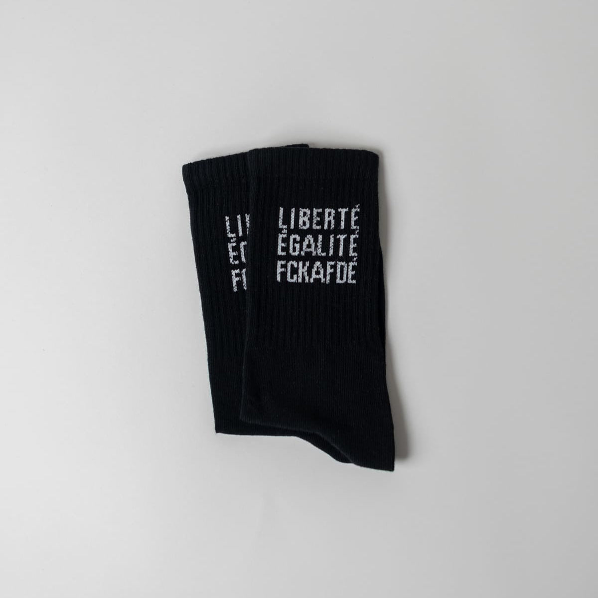 Liberté. Égalité. FCKAFDÉ Statement Socken in schwarz vor weißem Hintergrund
