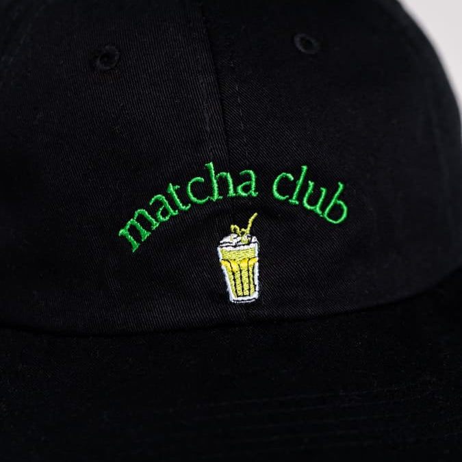 Nahaufnahme der Matcha Club Organic cap in schwarz mit grünem Design