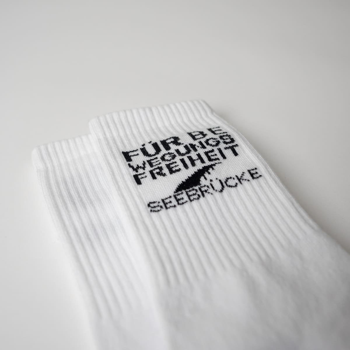Nahaufnahme der Für Bewegungsfreiheit Socken von arrel und der Seebrücke
