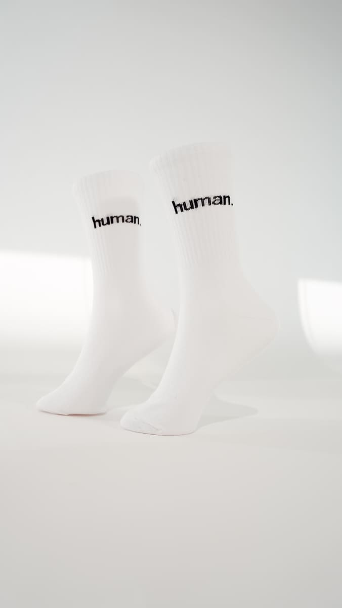 human. Statementsocken von arrel in weiß mit schwarzer Schrift am Modelfuß