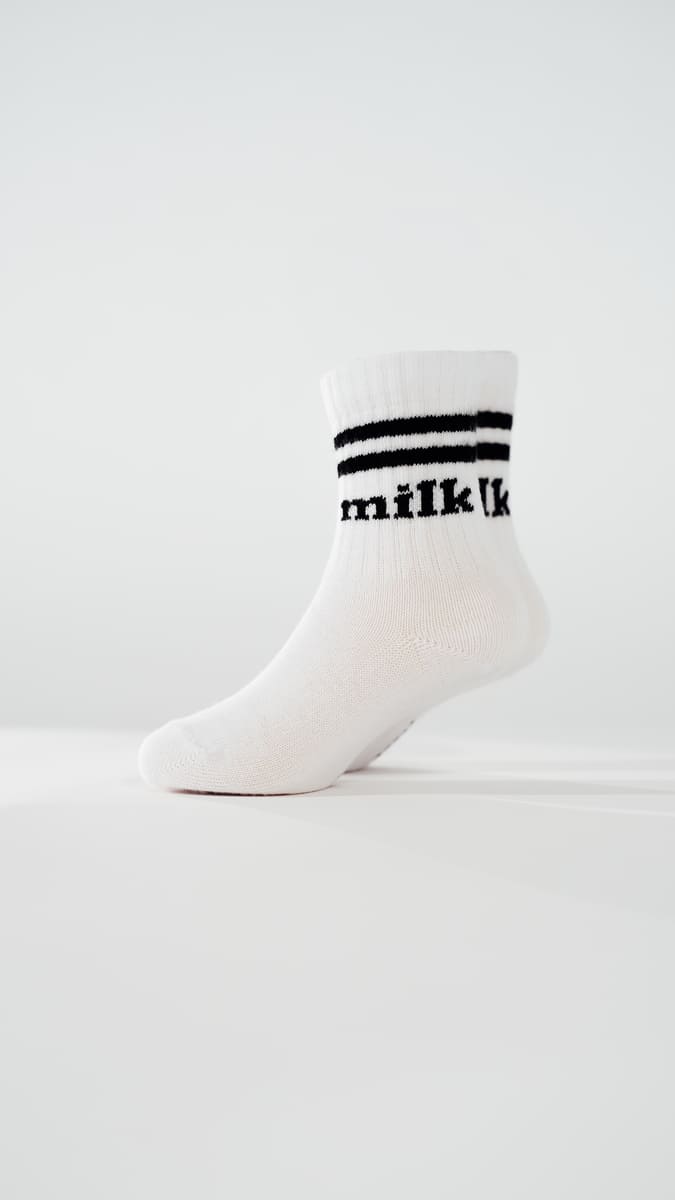 milk Socken von arrel am Modellfuß in weiß mit schwarzer Schrift