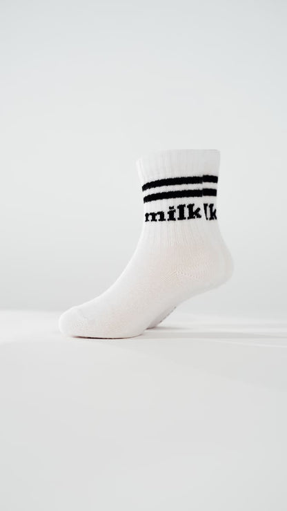 milk Socken von arrel am Modellfuß in weiß mit schwarzer Schrift