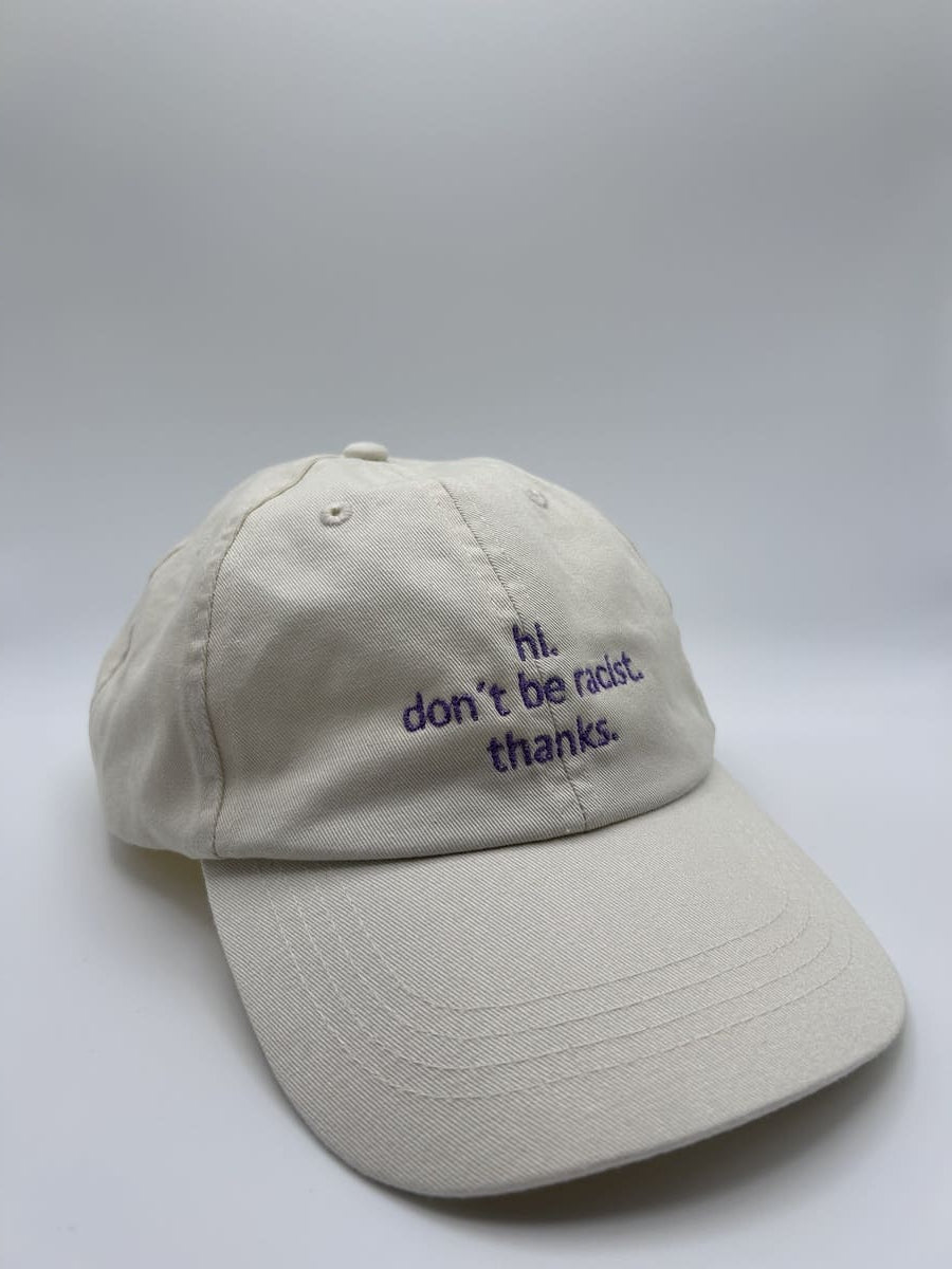 hi don't be racist dad cap von arrel in beige mit lavendelfarbener Schrift von schräg vorne fotografiert