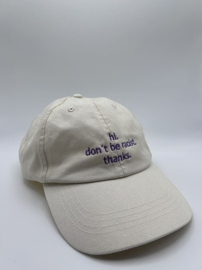 hi don't be racist dad cap von arrel in beige mit lavendelfarbener Schrift von schräg vorne fotografiert