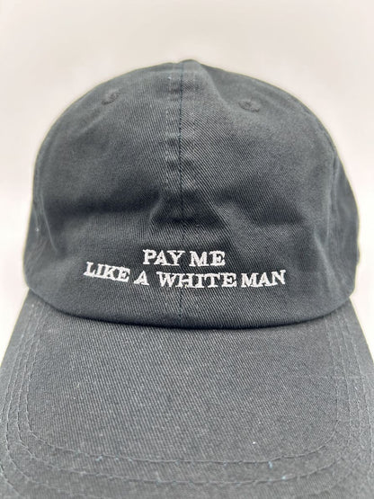 Nahaufnahme der pay me like a white man dad cap von arrel in schwarz mit weißer Schrift