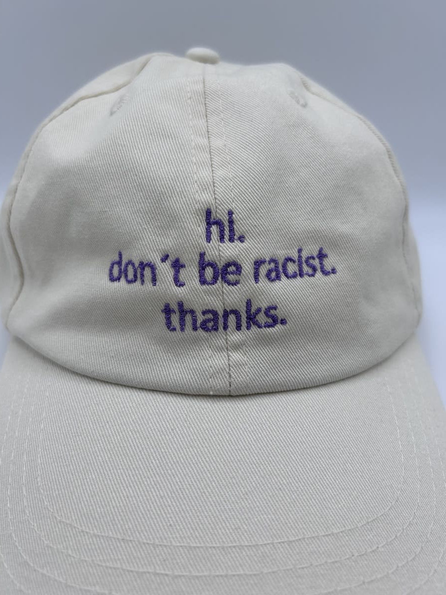 Nahaufnahme der hi don't be racist dad cap von arrel in beige mit lavendelfarbener Schrift