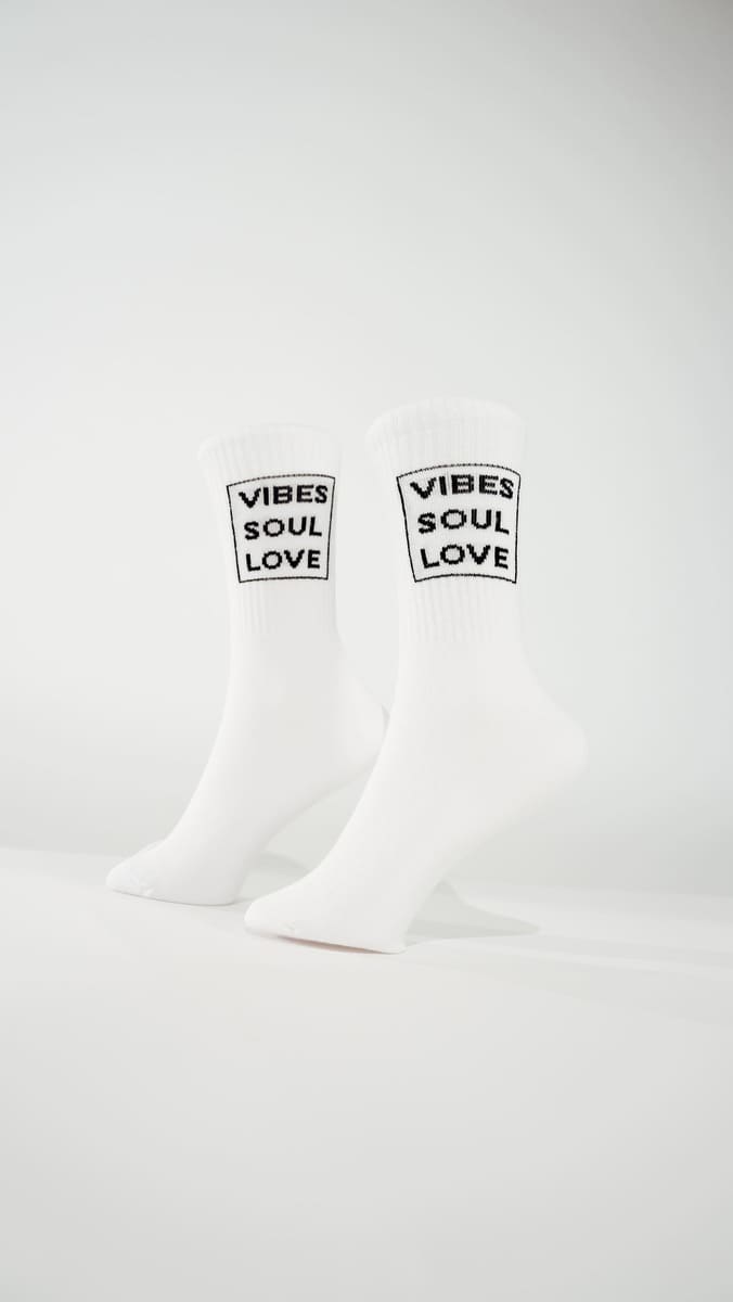 Vibes Soul Love Statementsocken von arrel aus Bio-Baumwolle am Modellfuß mit weißem Hintergrund
